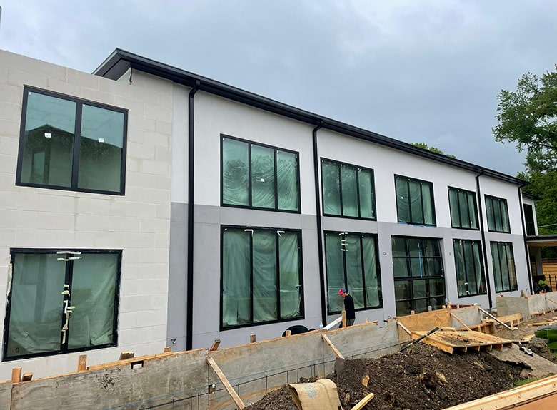 Modern two-story building under construction with exposed exterior and construction materials.